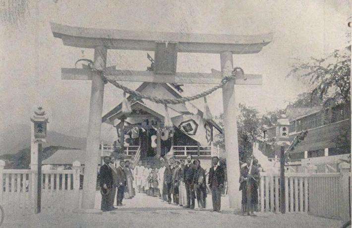 A wooden torii gate with a group of people standing beneath it, in Honolulu around 1911